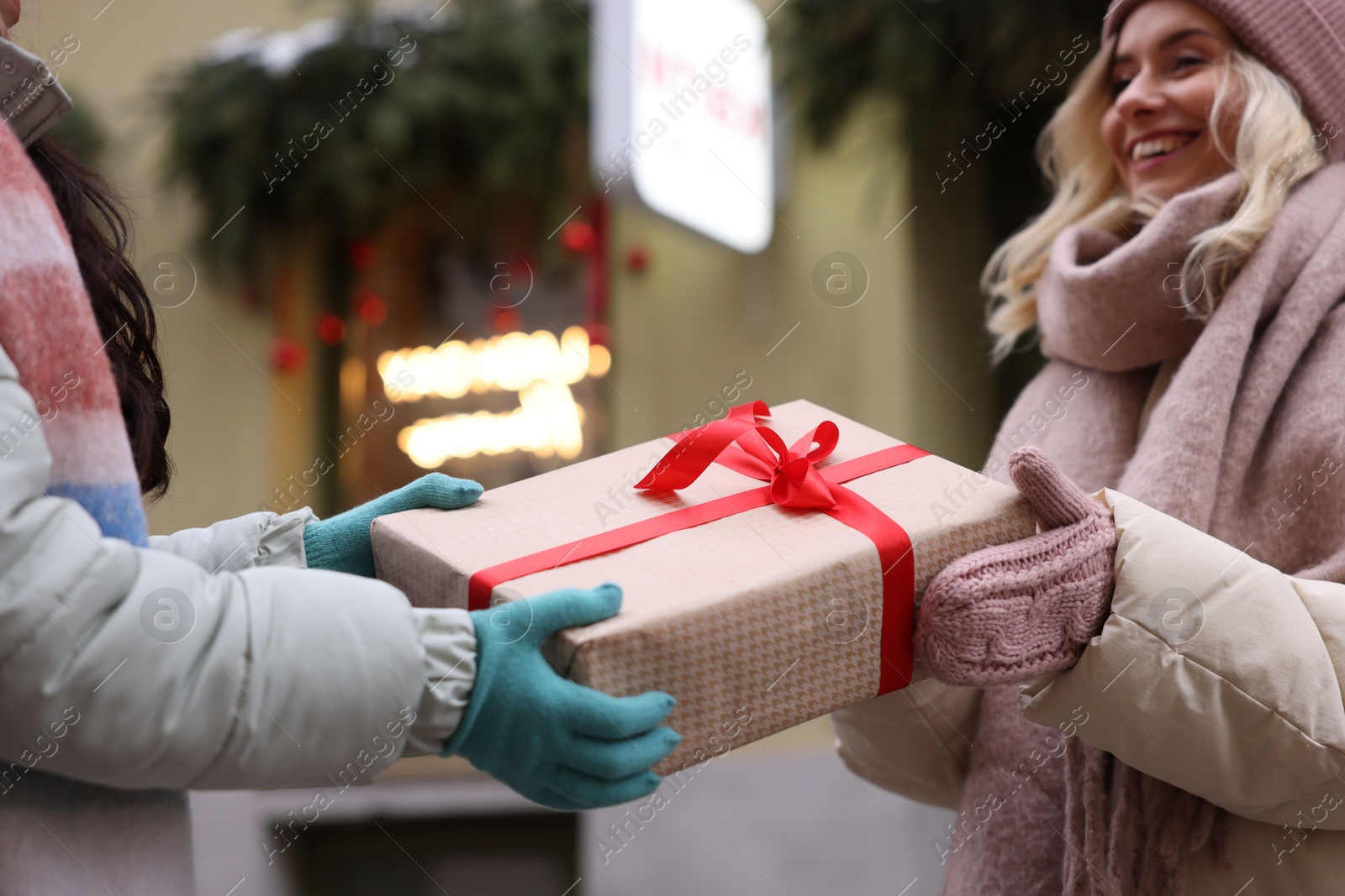 Photo of Friends with Christmas gift on city street, selective focus