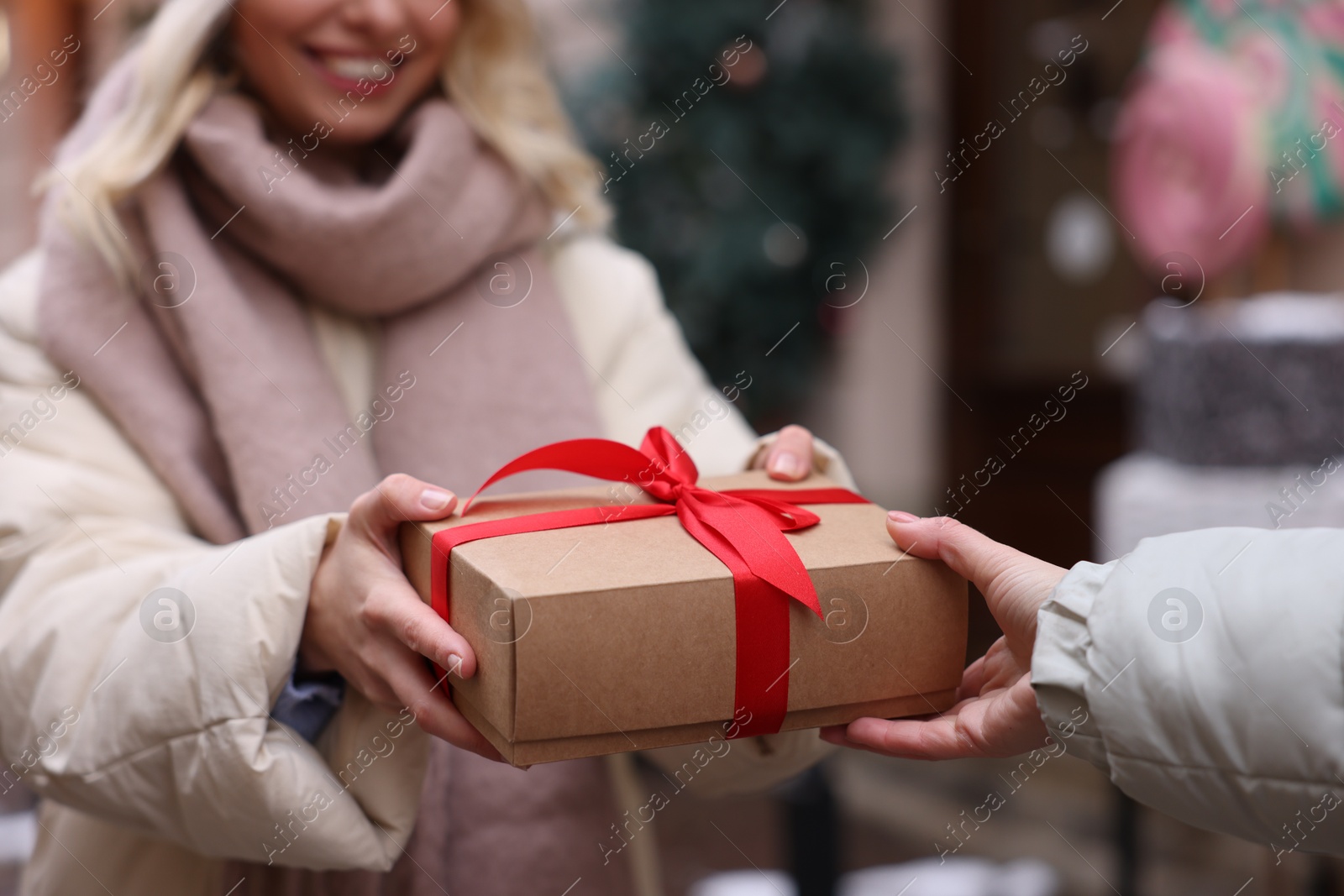 Photo of Friends with Christmas gift on city street, closeup