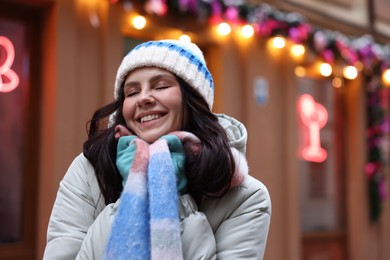 Photo of Portrait of happy woman near shop outdoors, space for text. Christmas season