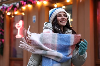 Photo of Portrait of happy woman near shop outdoors, space for text. Christmas season