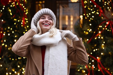 Photo of Portrait of happy woman on city street. Christmas season