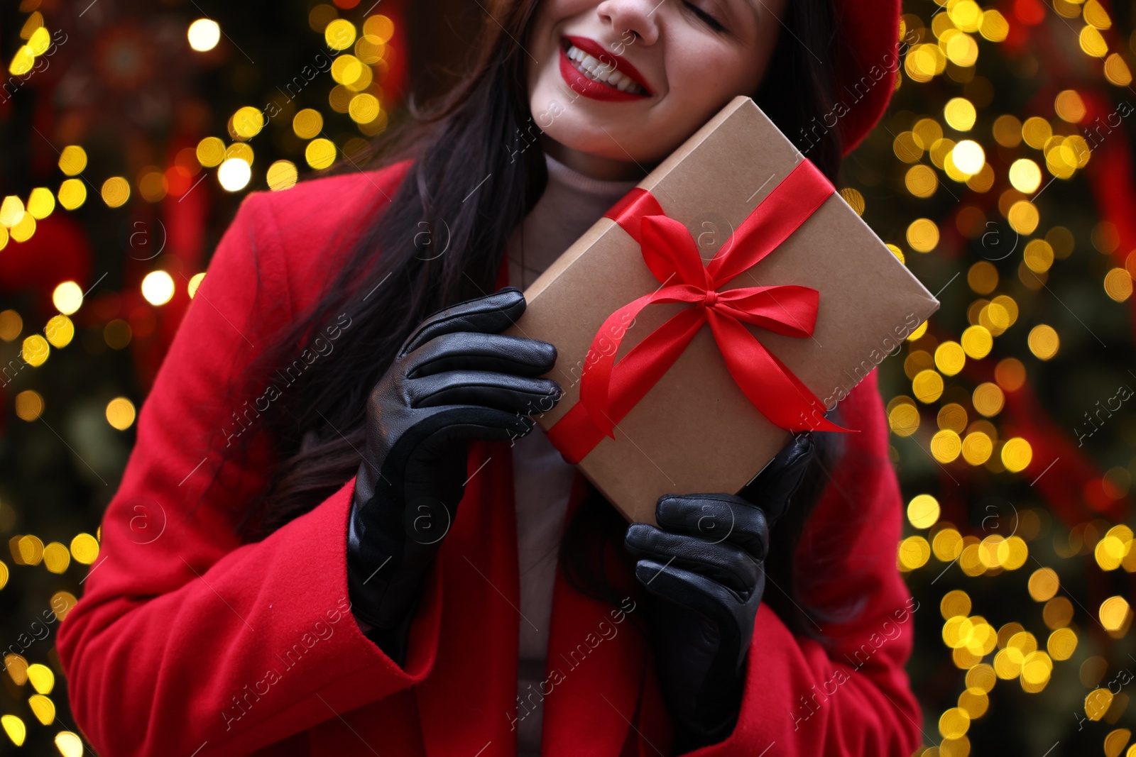 Photo of Woman with Christmas gift on city street, closeup