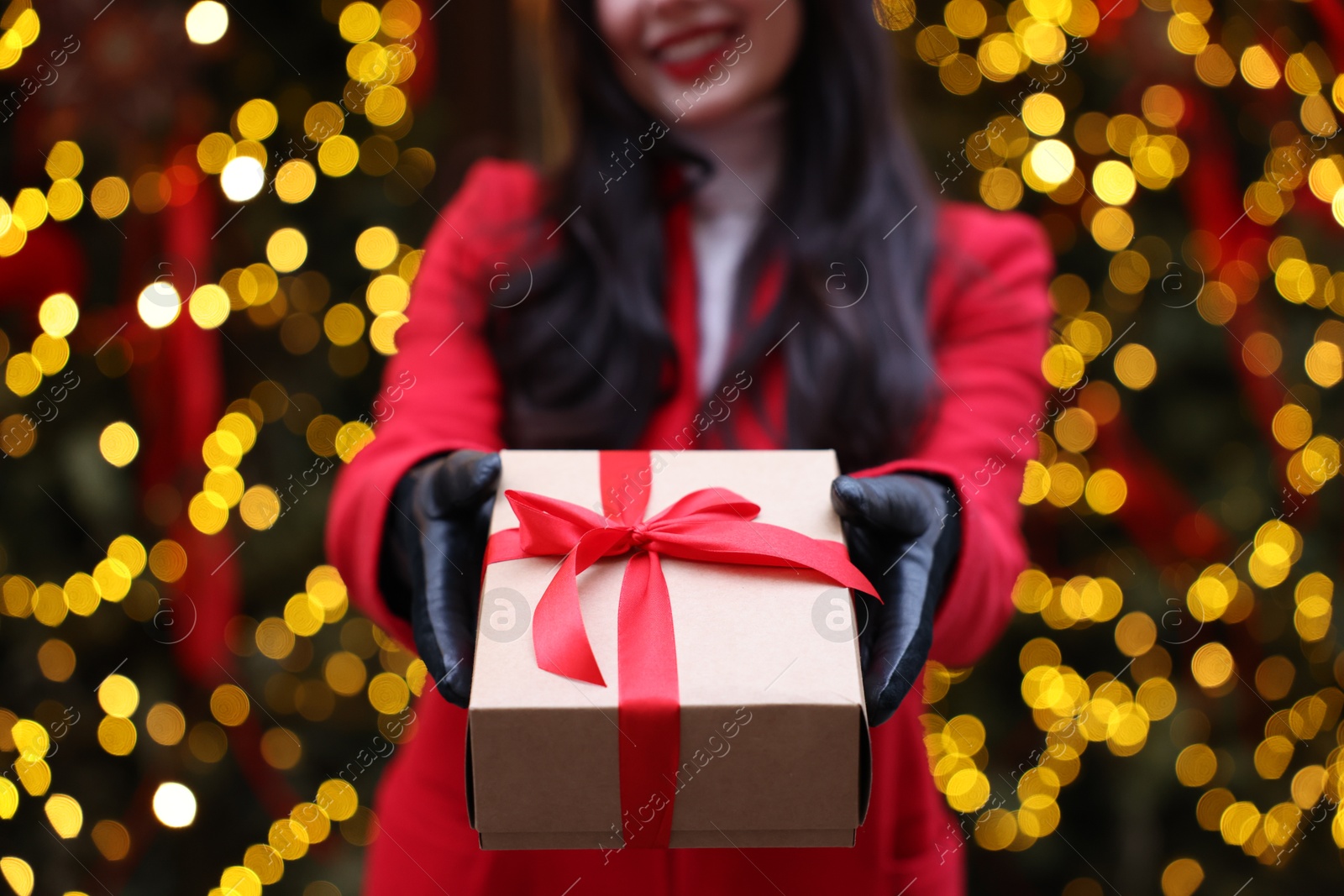 Photo of Woman with Christmas gift on city street, closeup