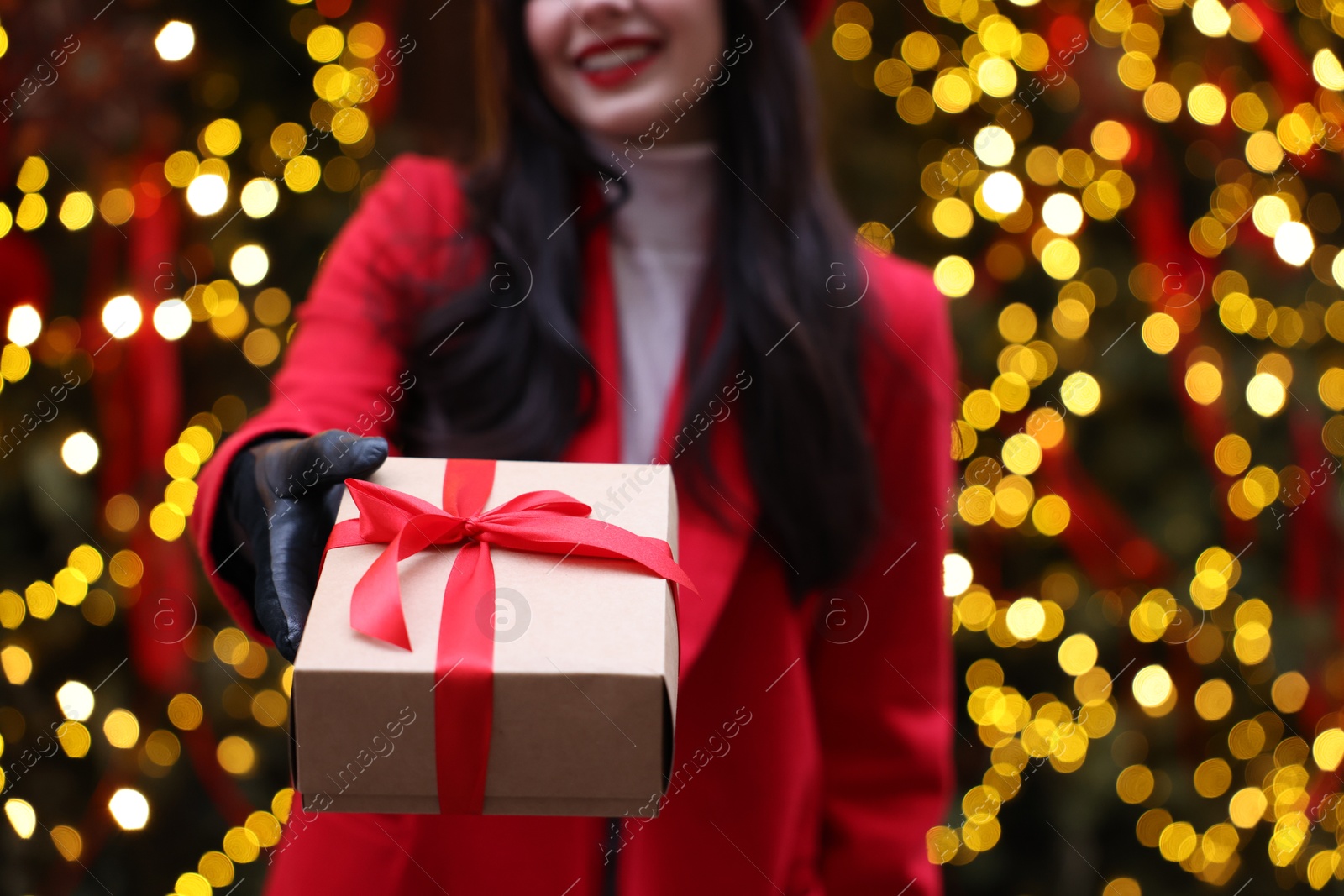 Photo of Woman with Christmas gift on city street, closeup