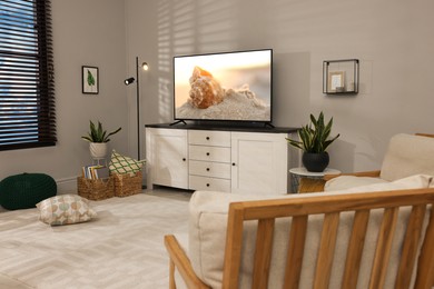 Image of TV set with nature landscape on screen in room