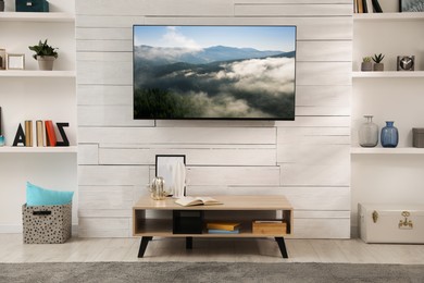 Image of TV set with nature landscape on screen in room