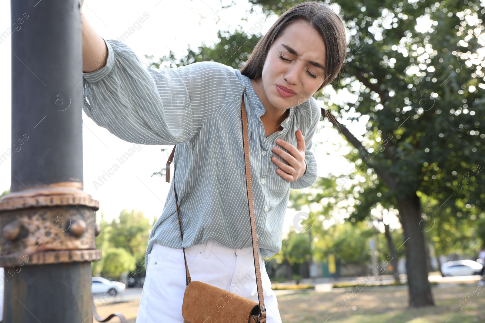 Photo of Young woman having heart attack in park