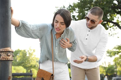 Photo of Man trying to help woman with heart attack in park