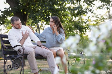 Photo of Woman calling ambulance to help man with heart attack in park