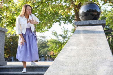 Photo of Young woman having heart attack in park