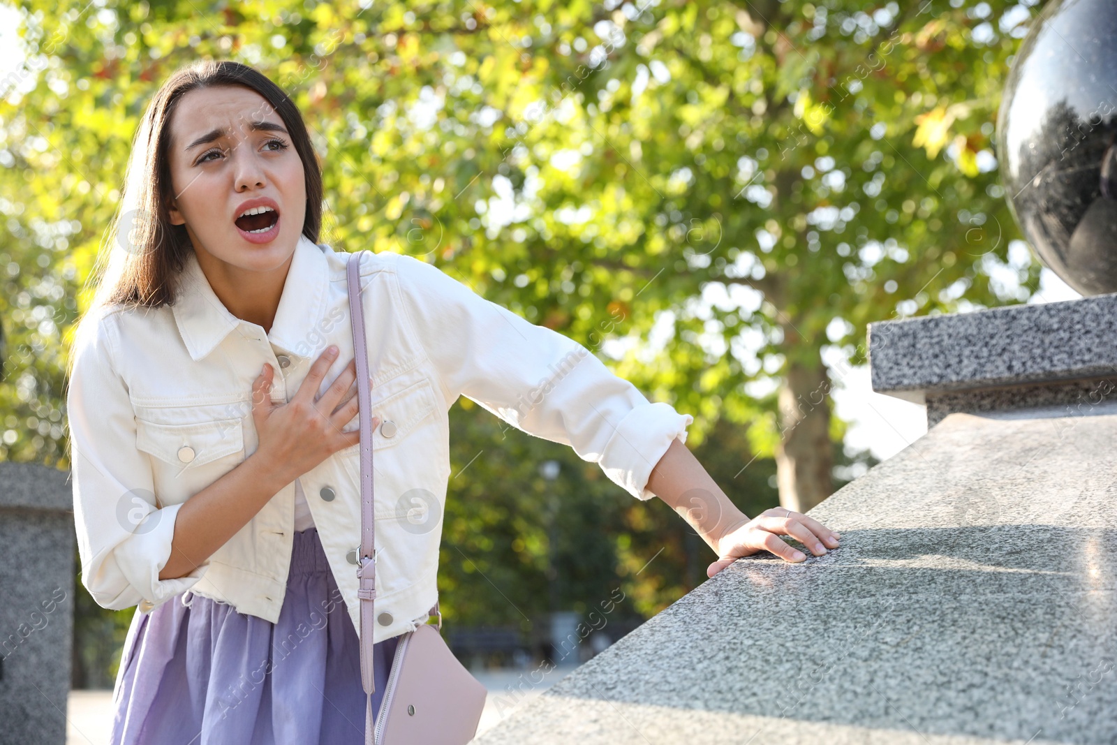 Photo of Young woman having heart attack in park