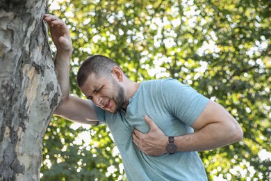 Photo of Man having heart attack near tree in park