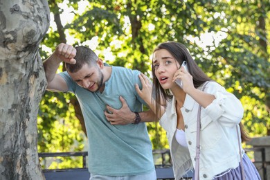 Photo of Woman calling ambulance to help man with heart attack in park