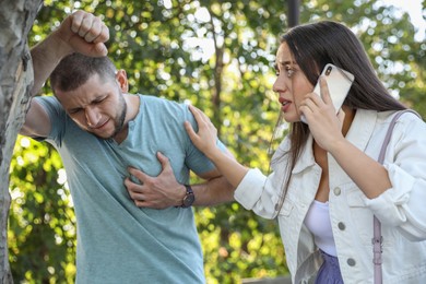 Photo of Woman calling ambulance to help man with heart attack in park