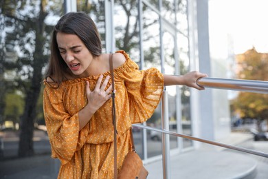 Photo of Young woman having heart attack on city street