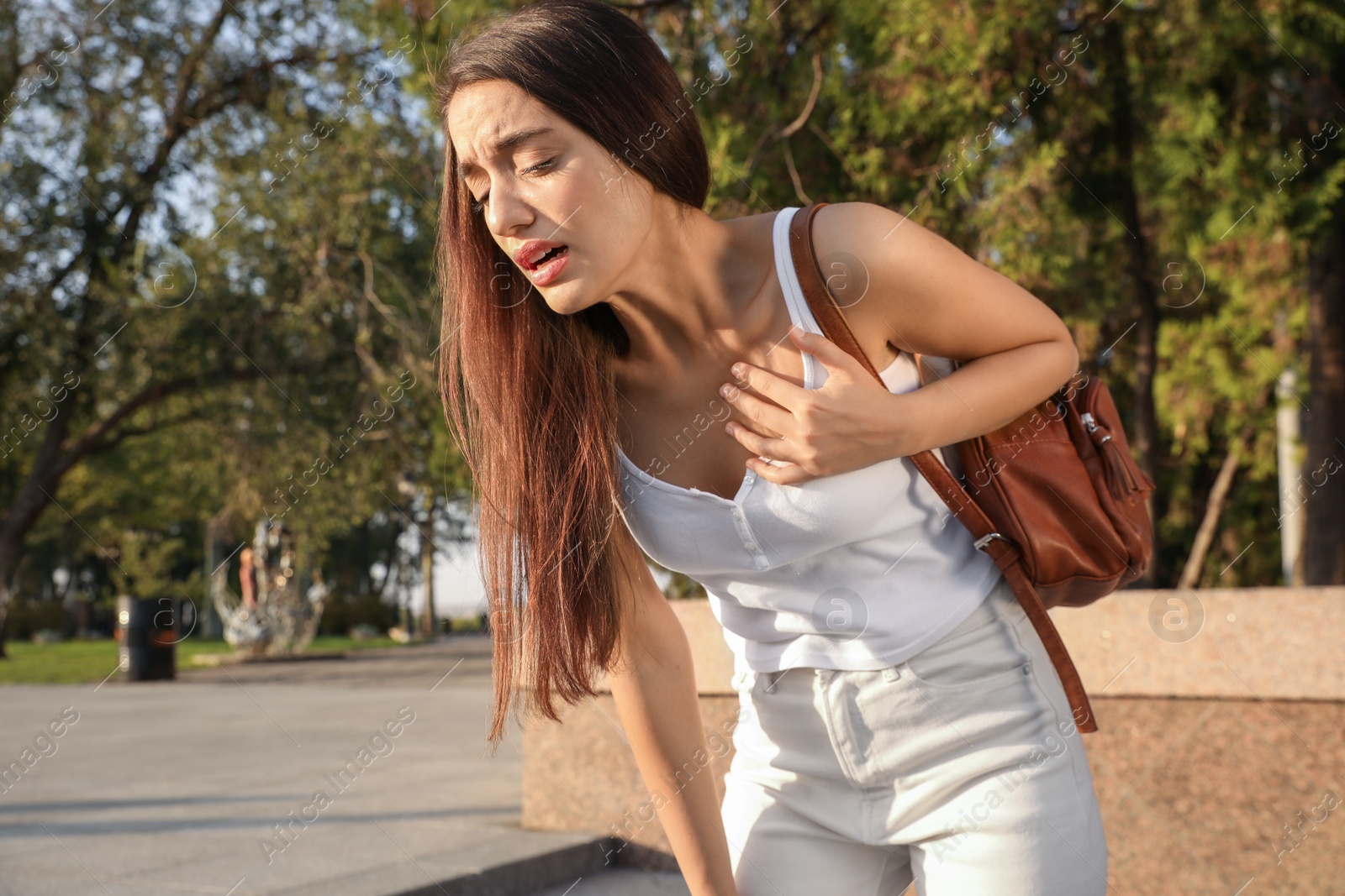 Photo of Young woman having heart attack on city street