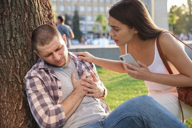 Photo of Woman trying to help man with heart attack in park