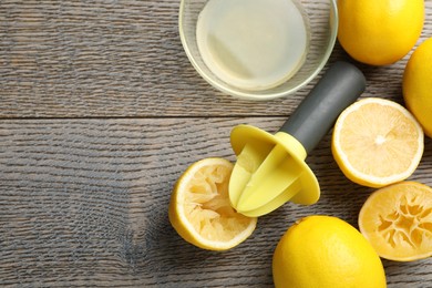 Photo of Plastic juicer and fresh lemons on grey wooden table, flat lay. Space for text