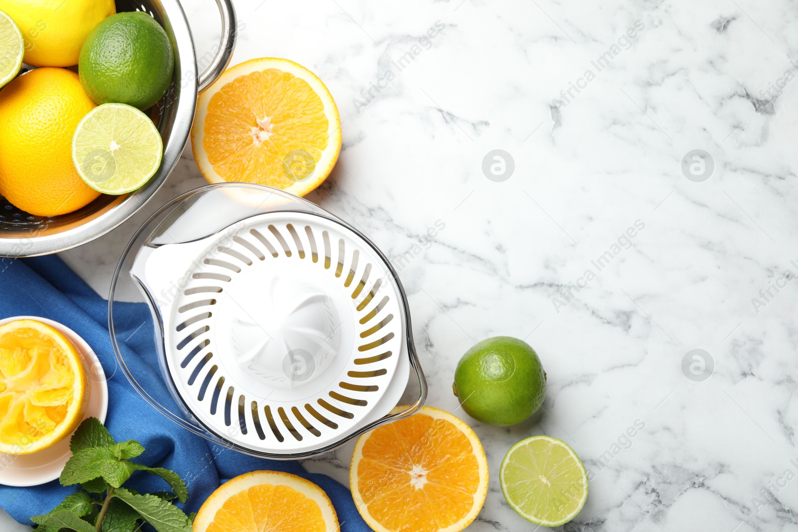 Photo of Plastic juicer and different citrus fruits on white marble table, flat lay. Space for text