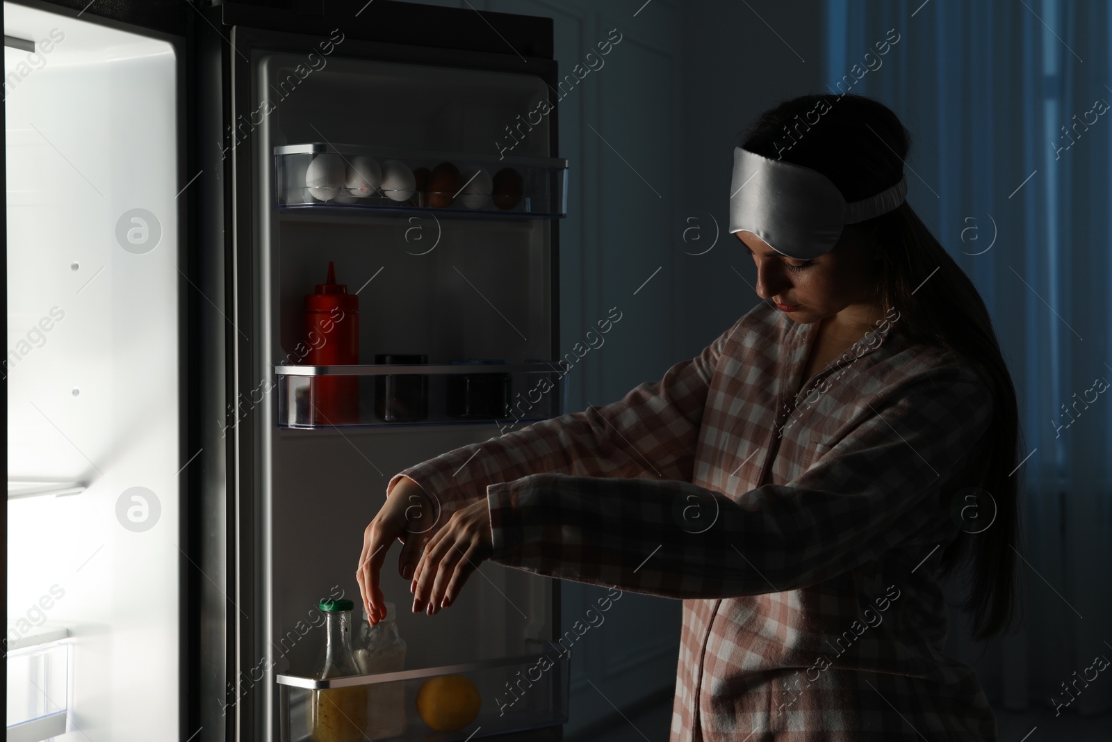 Photo of Young woman suffering from sleepwalking near fridge at home