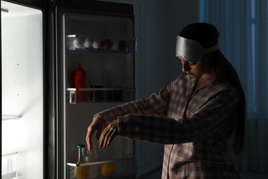 Photo of Young woman suffering from sleepwalking near fridge at home