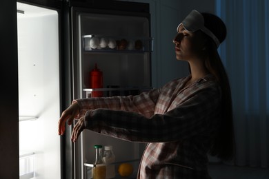 Photo of Young woman suffering from sleepwalking near fridge at home