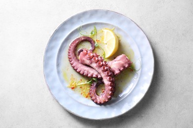 Photo of Appetizing octopus tentacles on light table, top view