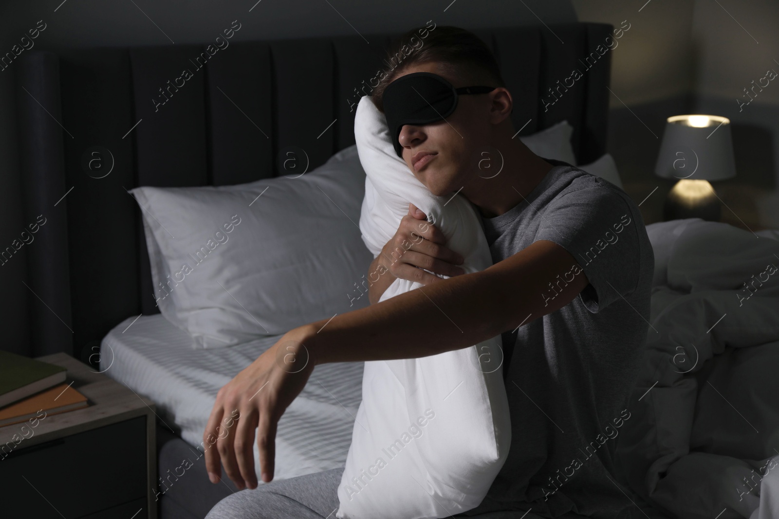 Photo of Young man suffering from sleepwalking on bed at home