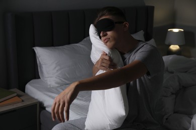 Photo of Young man suffering from sleepwalking on bed at home