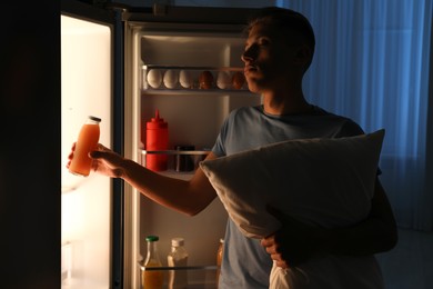 Photo of Young man suffering from sleepwalking near fridge at home