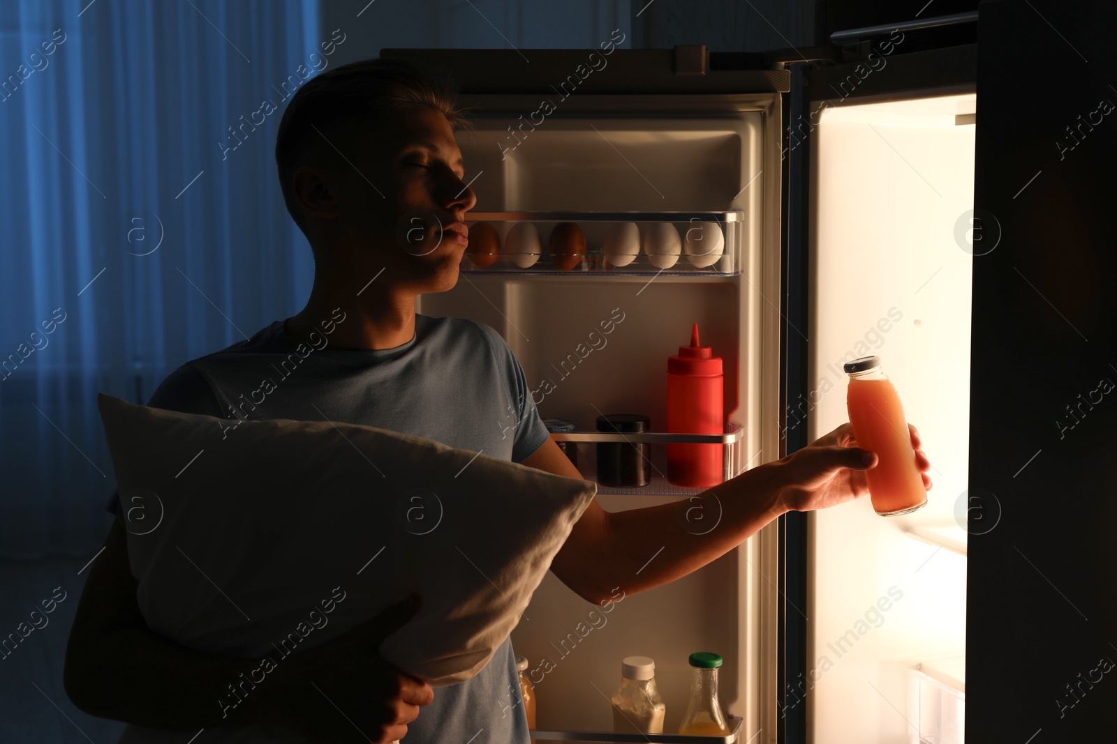 Photo of Young man suffering from sleepwalking near fridge at home