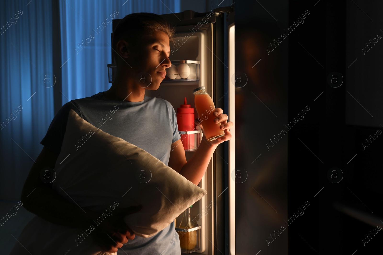 Photo of Young man suffering from sleepwalking near fridge at home