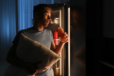 Photo of Young man suffering from sleepwalking near fridge at home