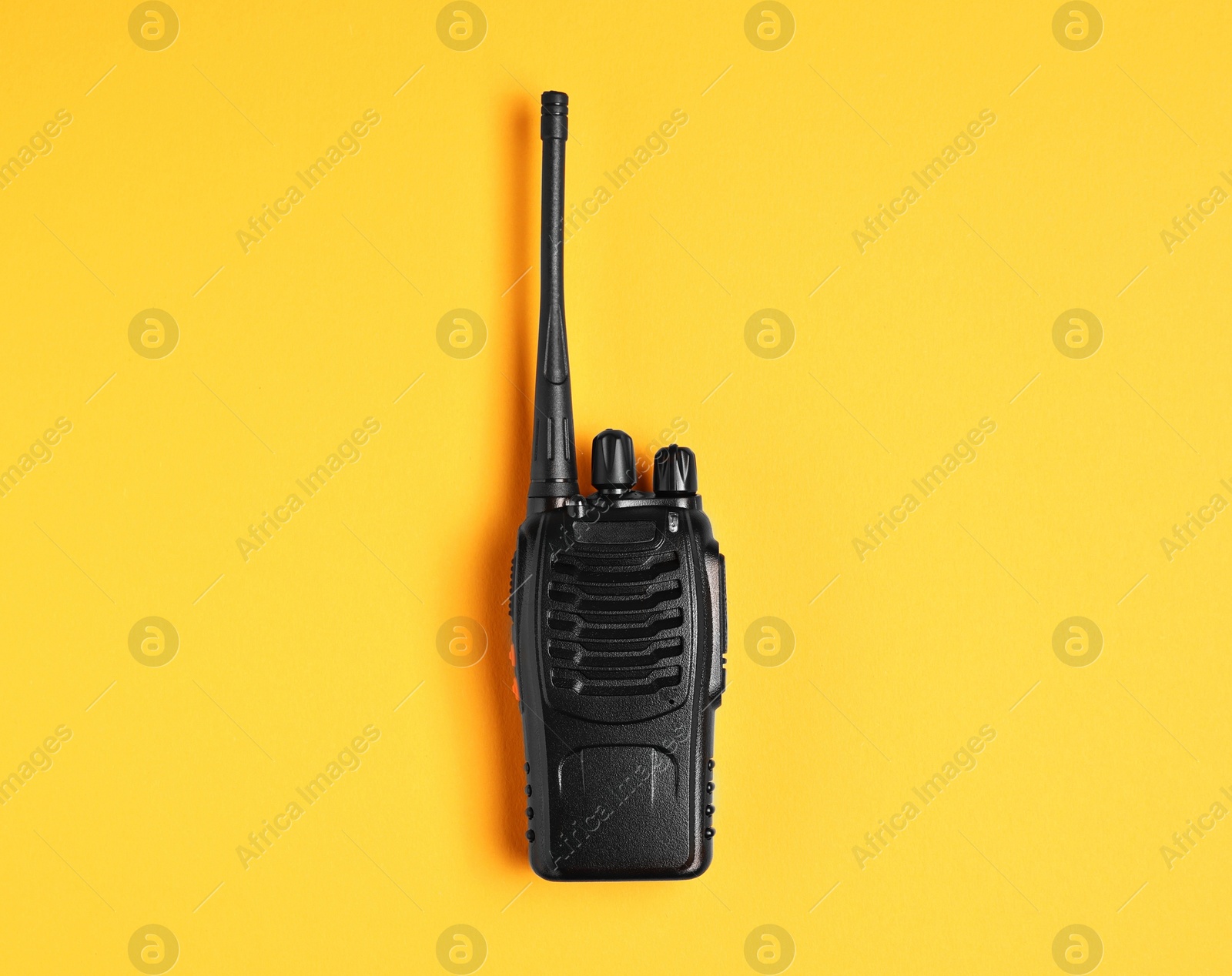 Photo of One walkie talkie on orange background, top view