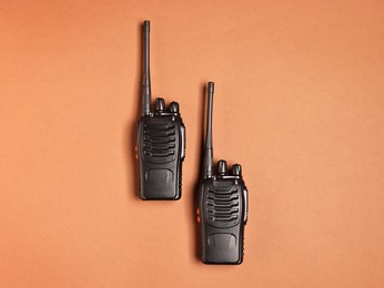 Photo of Walkie talkies on brown background, top view