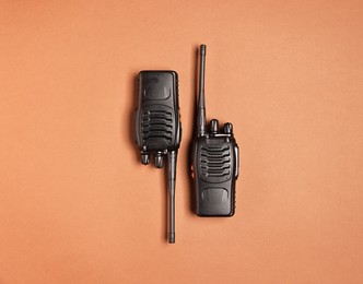 Photo of Walkie talkies on brown background, top view