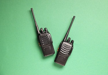 Photo of Walkie talkies on green background, top view