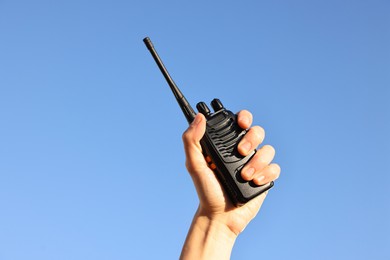 Photo of Woman with walkie talkie against blue sky outdoors, closeup