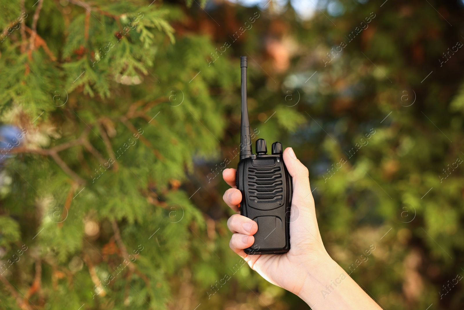 Photo of Woman with walkie talkie in park, closeup