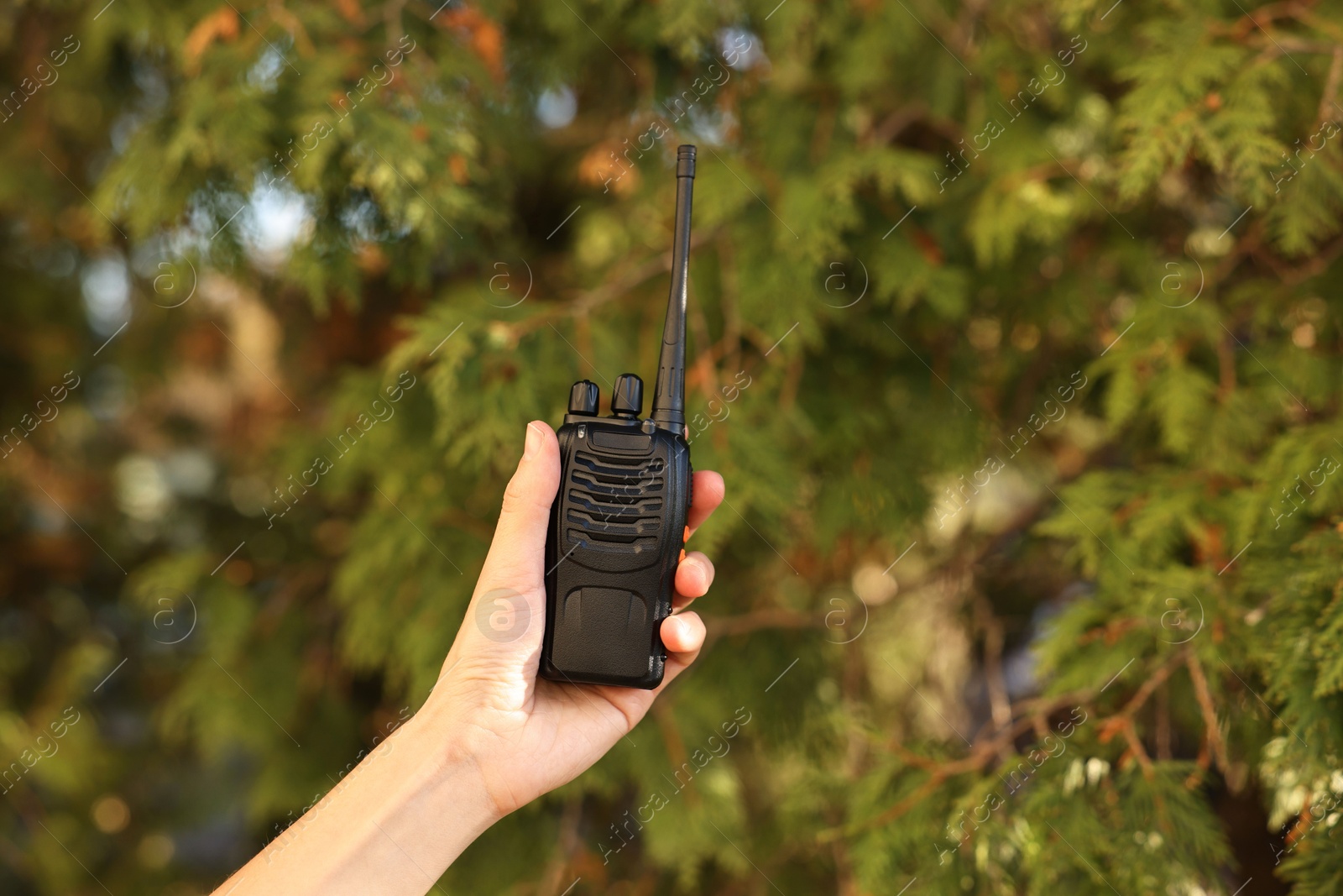 Photo of Woman with walkie talkie in park, closeup