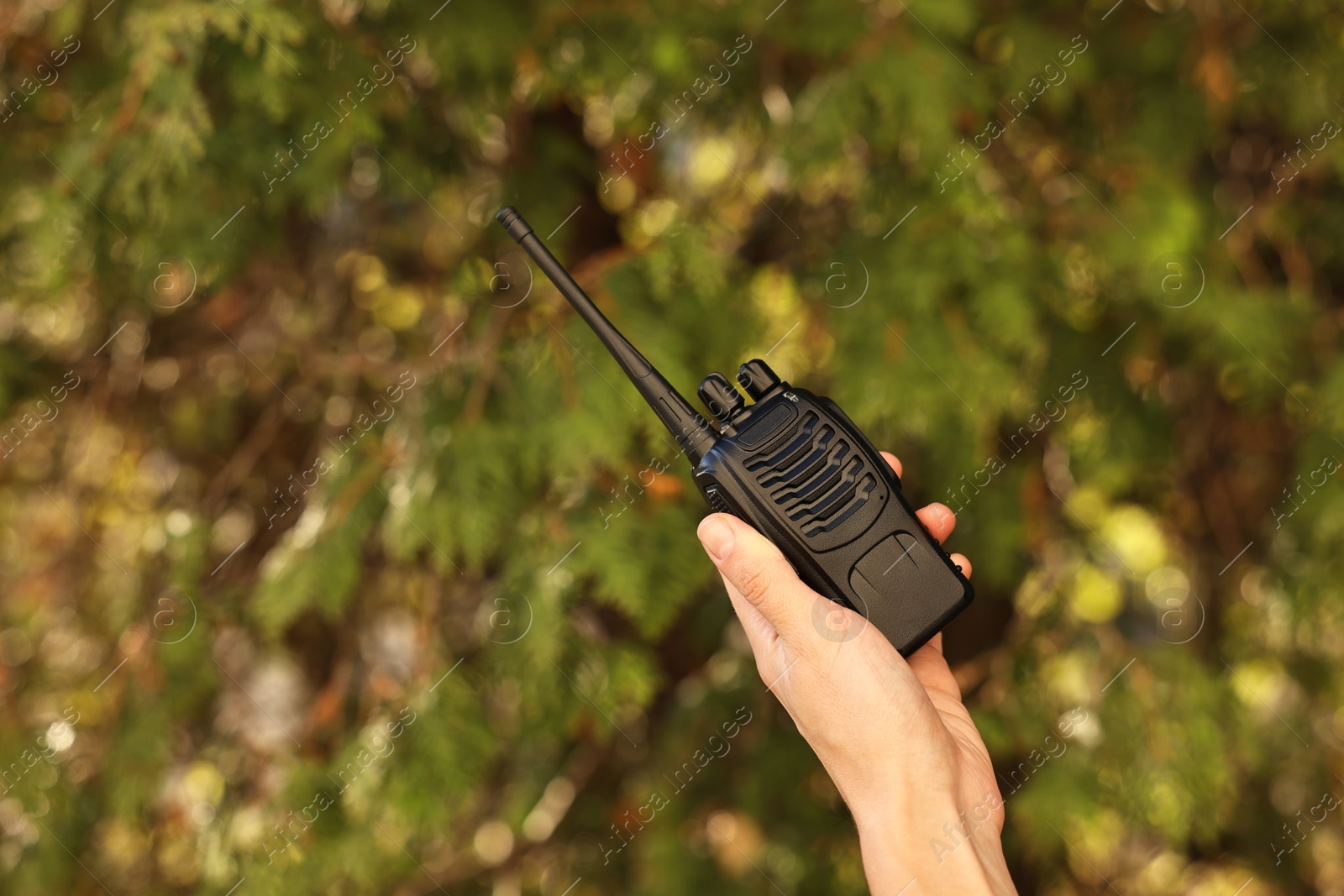 Photo of Woman with walkie talkie in park, closeup. Space for text