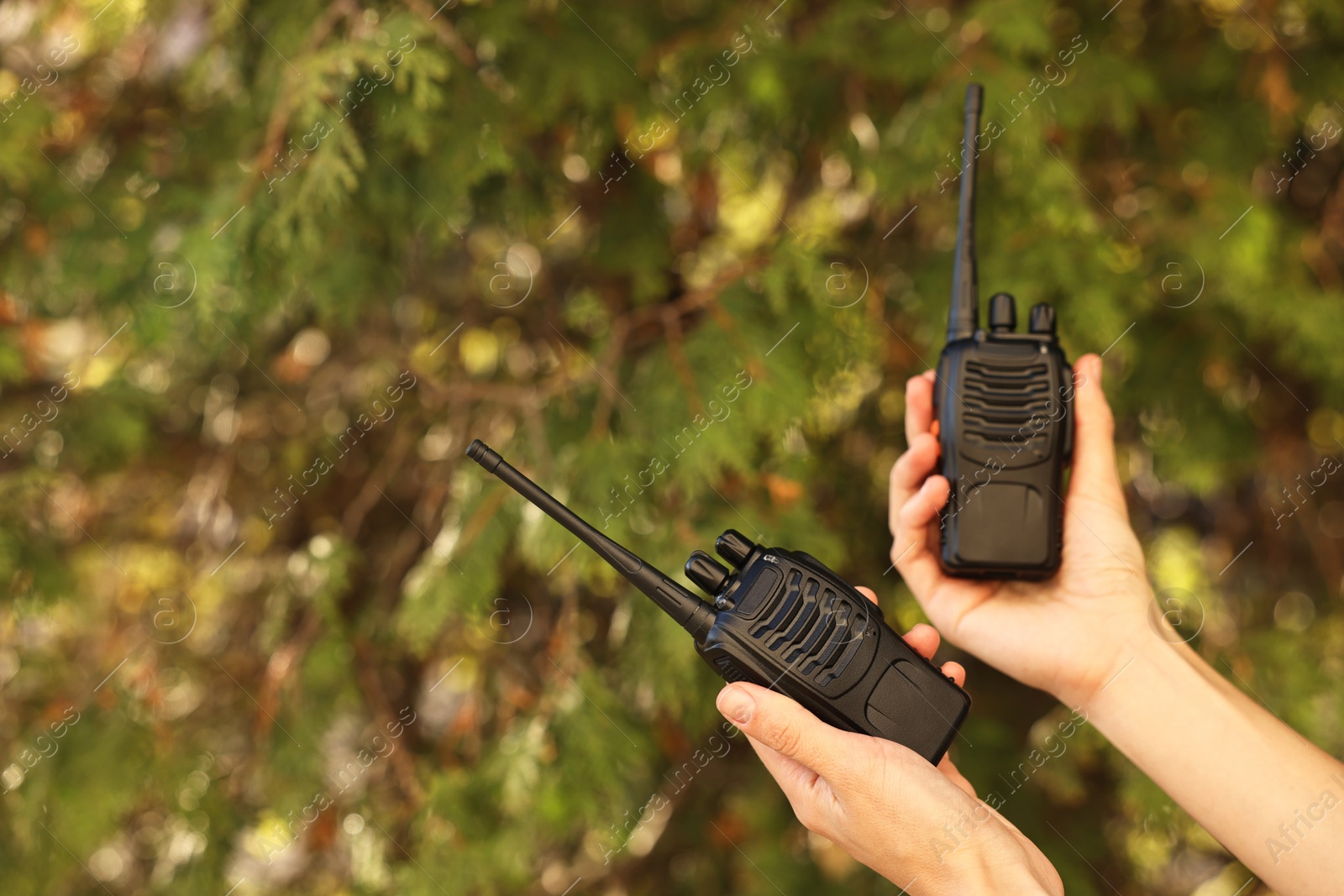 Photo of Woman with walkie talkies in park, closeup. Space for text