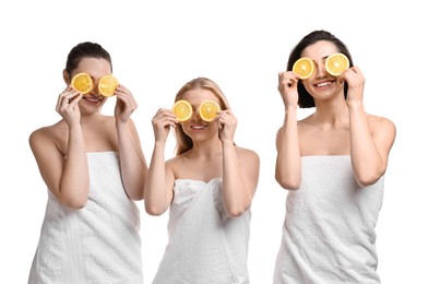 Photo of Spa day. Cheerful women wrapped in towels with orange slices on white background