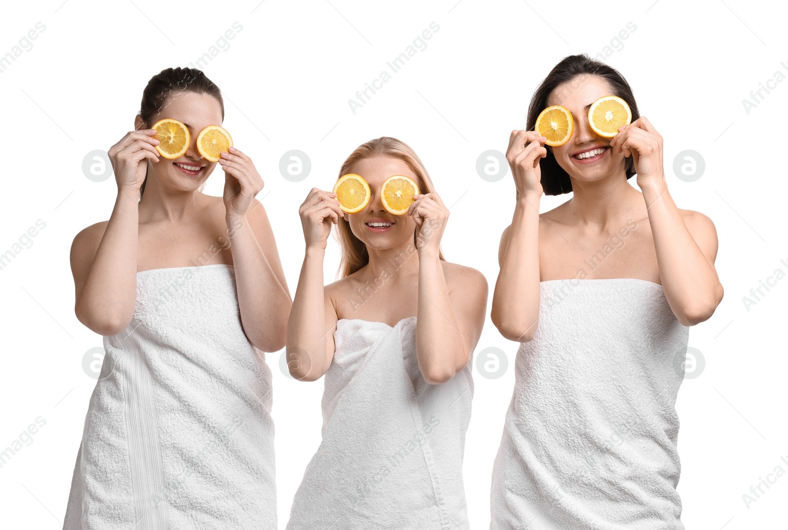 Photo of Spa day. Cheerful women wrapped in towels with orange slices on white background