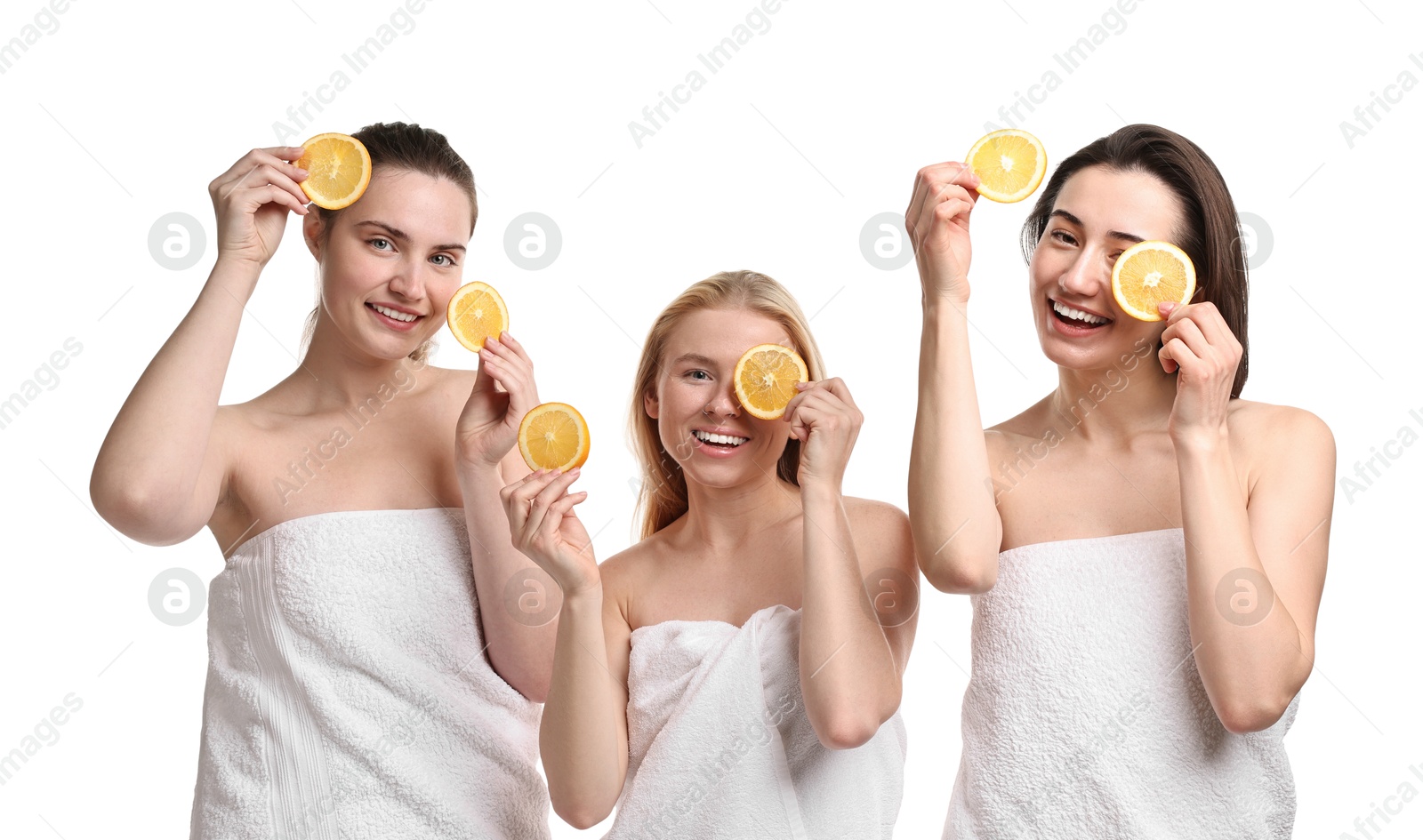 Photo of Spa day. Cheerful women wrapped in towels with orange slices on white background