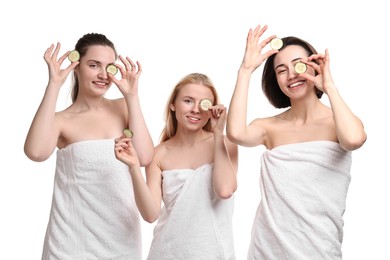 Photo of Spa day. Cheerful women wrapped in towels with cucumber slices on white background