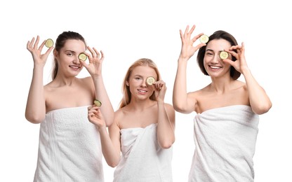 Photo of Spa day. Cheerful women wrapped in towels with cucumber slices on white background