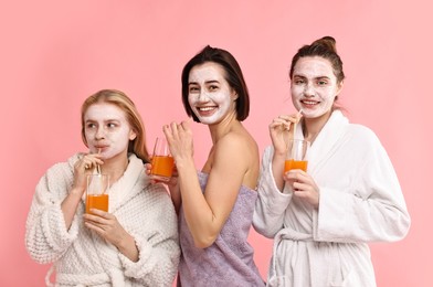 Photo of Spa day. Beautiful women with face masks and healthy drinks on pink background