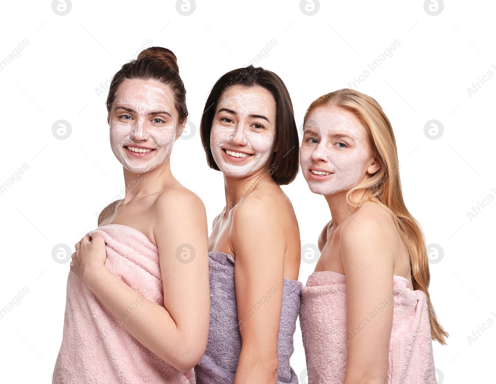 Photo of Spa day. Beautiful women with face masks wrapped in towels on white background