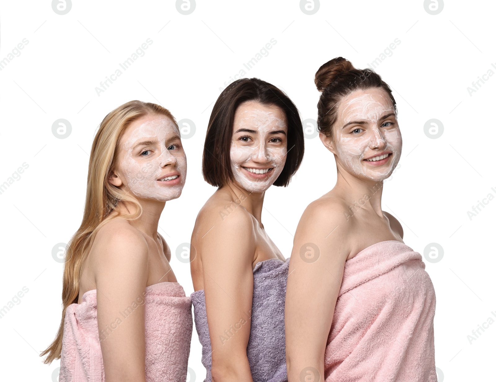 Photo of Spa day. Beautiful women with face masks wrapped in towels on white background